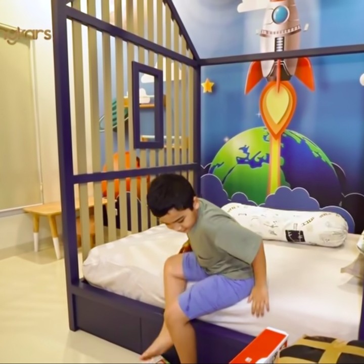 <p>Kamar Adam didominasi dengan warna biru yang gagah, Bunda. Kamar ini mengambil konsep astronaut dan ruang angkasa, lho. (Foto: YouTube The Sungkars)</p>