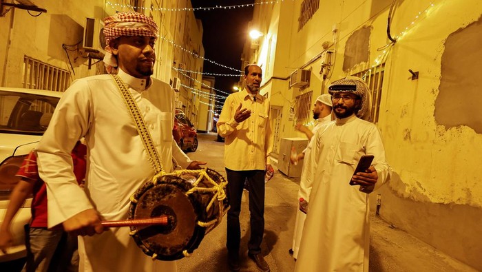 Ali Sammak plays a drum while Yasser Sammak sings religious songs, keeping the tradition of 