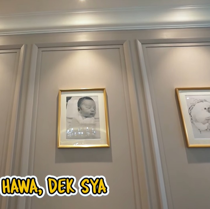 <p>Shireen Sungkar memejang foto ketiga anaknya di ruang kaluarga. Foto-foto ini menjadi salah satu pajangan selain lukisan. (Foto: YouTube The Sungkars)</p>