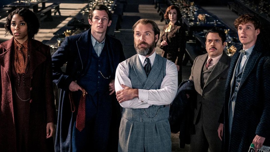This image released by Warner Bros. Pictures shows, from left, Jessica Williams, Callum Turner, Jude Law, Fionna Glascott, Dan Fogler and Eddie Redmayne in a scene from 