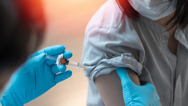1316009633 Young doctor giving COVID 19 vaccine to young woman at home