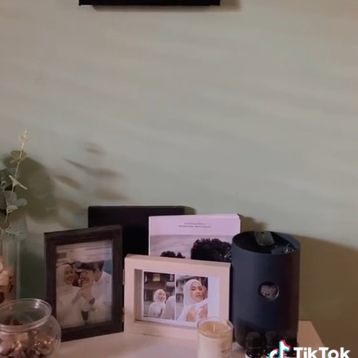 <p>Mengusung konsep minimalis, pasangan itu hanya menghiasi kontrakan mereka dengan beberapa foto momen penting di sudut meja. (Foto: TikTok @abadibersamaadelweis)</p>