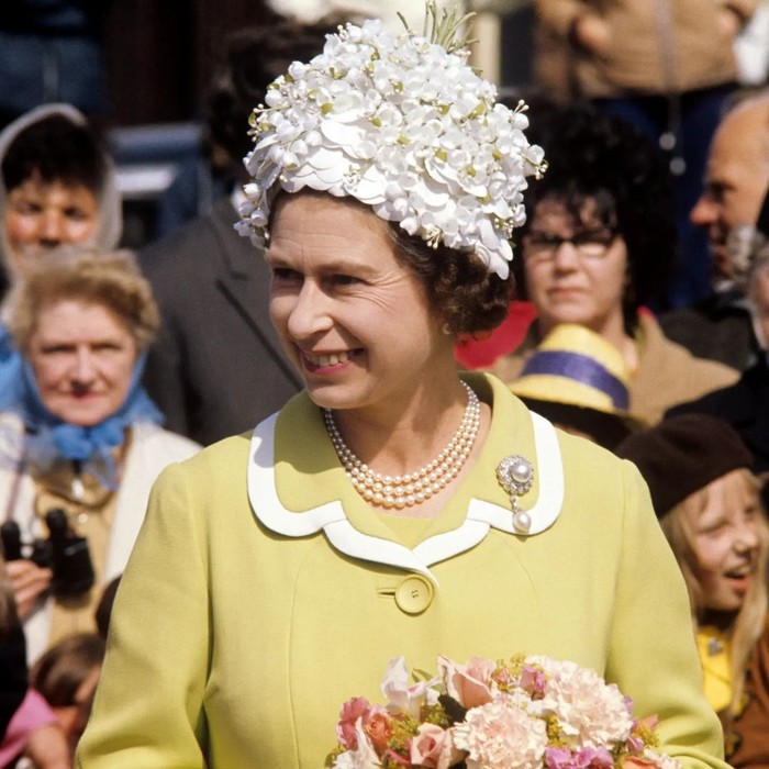 Di era 1970an, pilihan topi berdesain playful jadi pilihannya. Seperti pada foto yang diambil pada tahun 1972 berikut di mana berhiaskan detail applique bunga. Selaras dengan busana warna kuning yang feminin. Foto: Instagram theroyalfamily