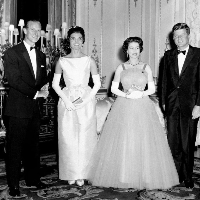 Pada tahun 1961, Ratu Elizabeth II menerima kunjungan kenegaraan Presiden Amerika Serikat kala itu Jack Kennedy bersama First Lady, Jackie. Sang Ratu tampil glamor dan elegan dalam balutan gaun detail lipit bervolume. Bersanding dengan Jackie yang memakai gaun berpotongan hourglass yang klasik.Foto: Instagram theroyalfamily