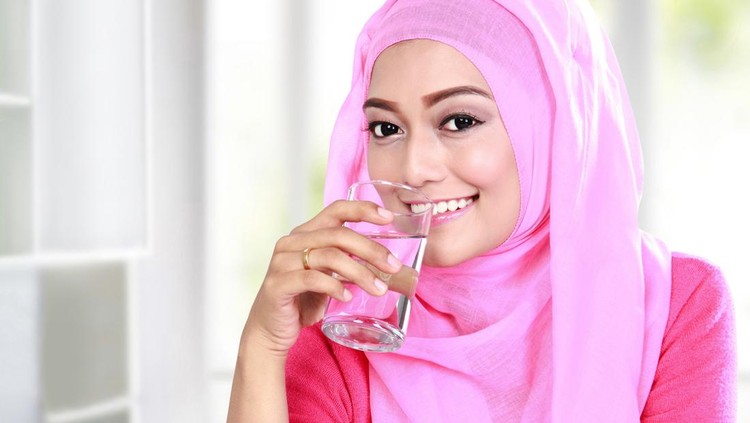 portrait of beautiful young muslim woman drink a glass of water