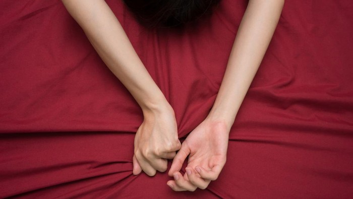 hand grasping on bed sheet