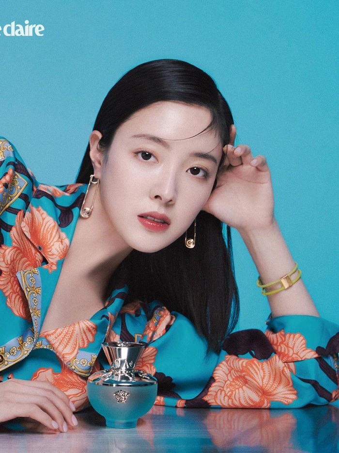 Dalam potret lainnya yang masih didominasi biru turqoise, Lee Se Young tampil chic dan elegan dengan kemeja bermotif serta variasi parfum lainnya dari Versace./ Foto: Yoon Ji Yong/instagram.com/marieclairekorea