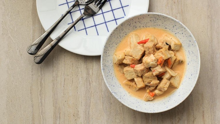 Sayur Tahu Tempe Cabe Pedas or Tofu Tempeh with Chilli and Coconut Milk is Traditional Indonesian Food Made from Diced Tempeh and Tofu  with Spicy Seasoning Served in Ceramic Bowl at the Table. Top View with Copy Space