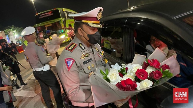 Pemudik yang pertama kali tiba di Gerbang Tol Kalikangkung, Semarang, saat penerapan aturan one way mendapatkan hadiah bunga dari petugas.
