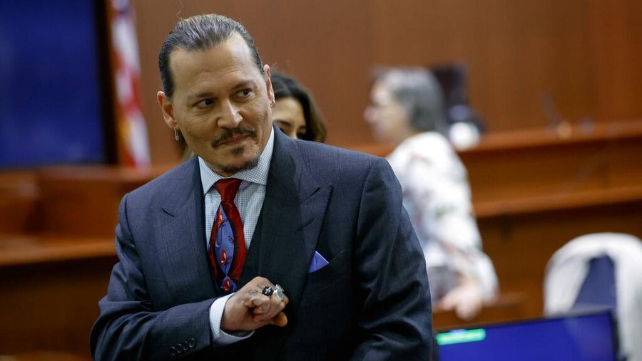 Actor Johnny Depp watches a pre-recorded deposition testimony of Christian Carino at the Fairfax County Circuit Court in Fairfax, Va., Wednesday, April 27, 2022. Depp sued his ex-wife actress Amber Heard for libel in Fairfax County Circuit Court after she wrote an op-ed piece in The Washington Post in 2018 referring to herself as a "public figure representing domestic abuse." (Jonathan Ernst/Pool Photo via AP)