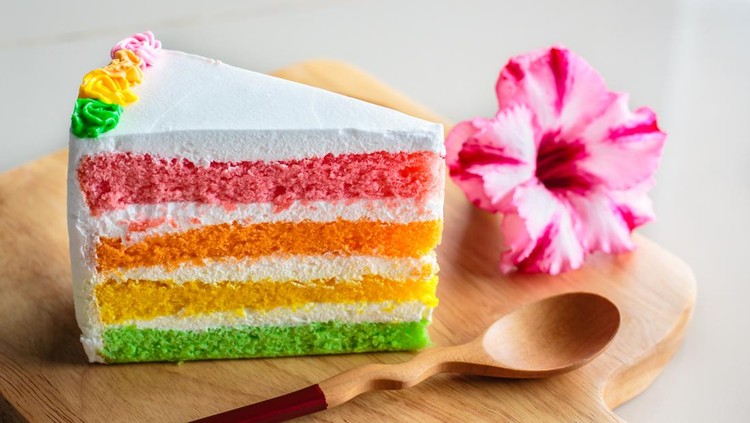 Slice of rainbow cake, Delicious rainbow cake on wood plate.