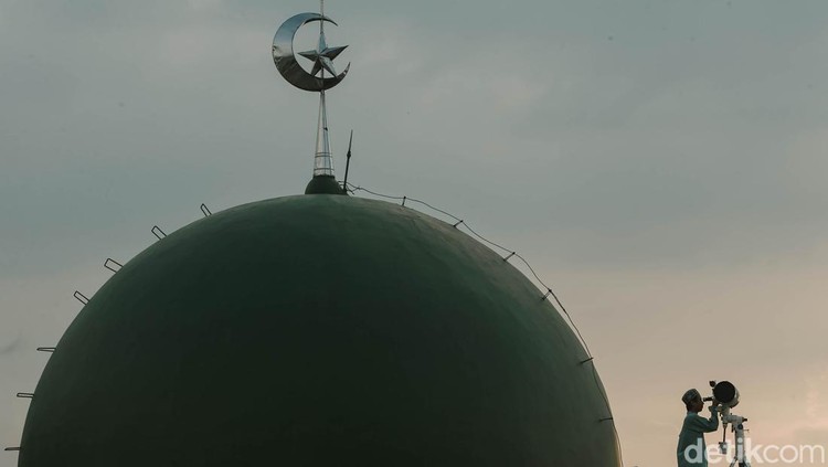 Petugas Masjid Al-Musyariin mengamati posisi hilal menggunakan teropong saat Rukyatul Hilal di Jakarta Barat, Minggu (1/5/2022). Pemantauan hilal yang dilakukan menggunakan teropong tersebut memastikan Idul Fitri 1443 H jatuh pada 2 Mei 2022.