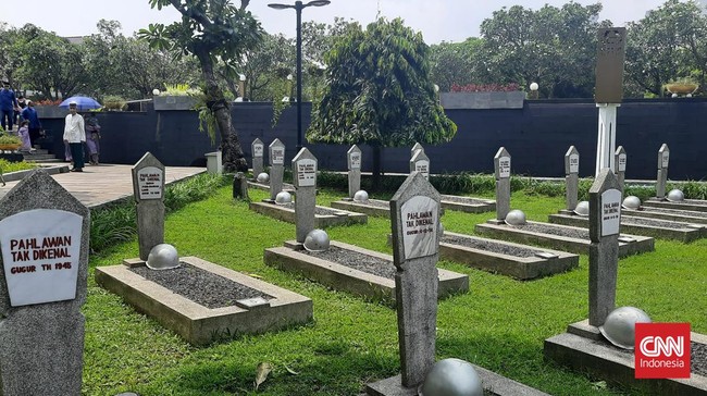 Berbaris makan Pahlawan Tak Dikenal di TMP Kalibata. Makam tersebut tergeletak tanpa bunga dan doa, di tengah keramaian peziarah di hari Lebaran.