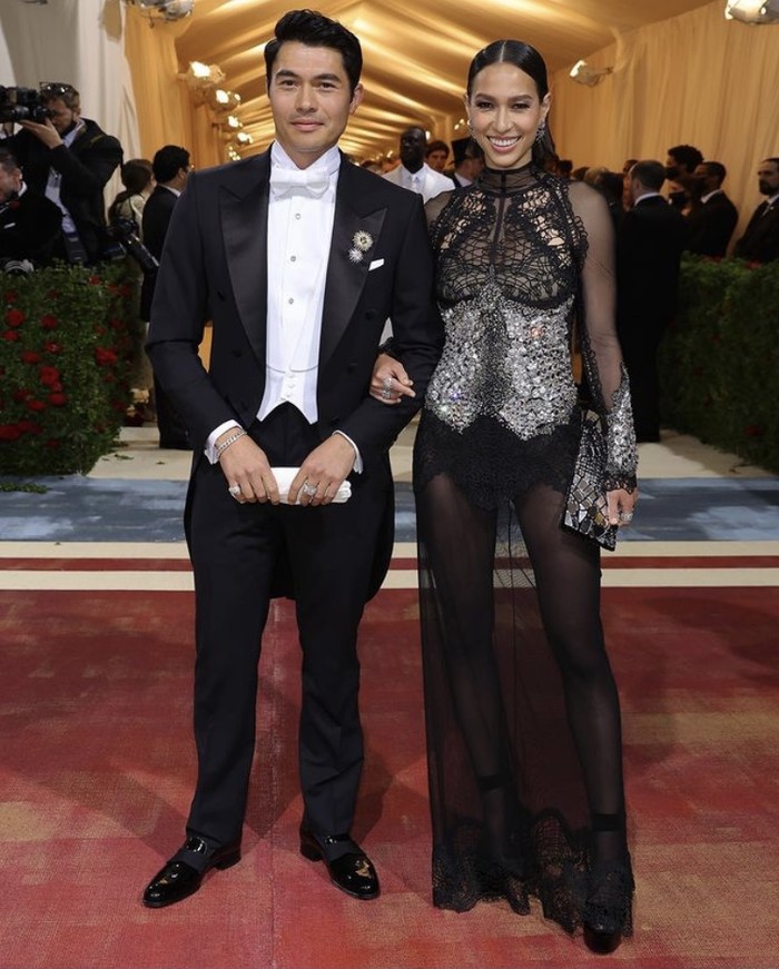 Sama-sama mengenakan busana kreasi Tom Ford, Henry Golding memancarkan nuansa elegan dalam tuxedo. Berdiri di sebelahnya, Liv Lo Golding tampil edgy dengan busana sheer, lace serta embellishment. Foto: instagram.com/tomford
