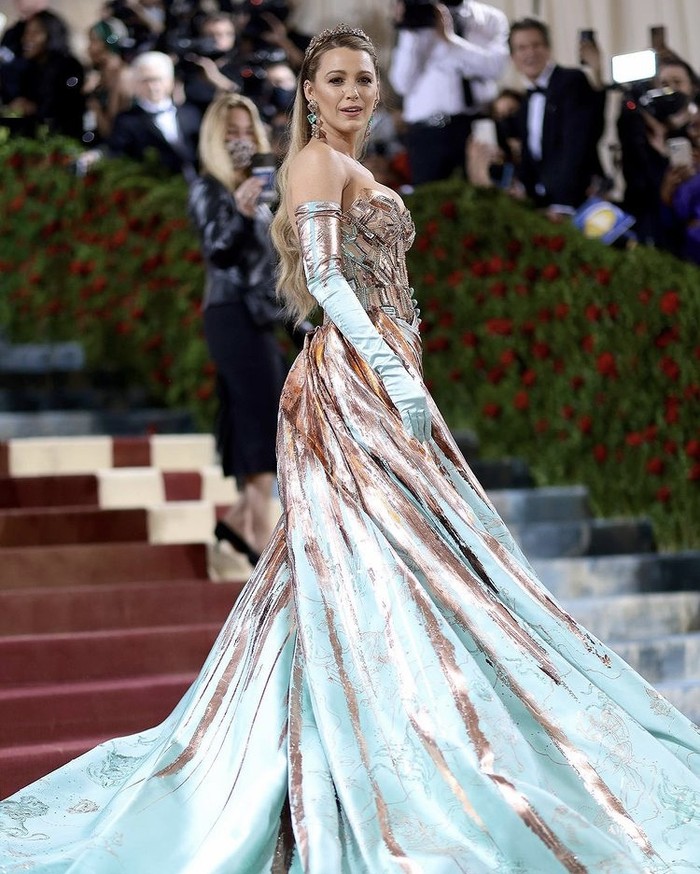 Co-chair Met Gala 2022, Blake Lively memenuhi dress code yang ditetapkan, bahkan melebihi ekspektasi. Gaun Versace two-toned, yakni bronze dan teal, dengan detail arsitektur bersejarah New York. Foto: instagram.com/versace