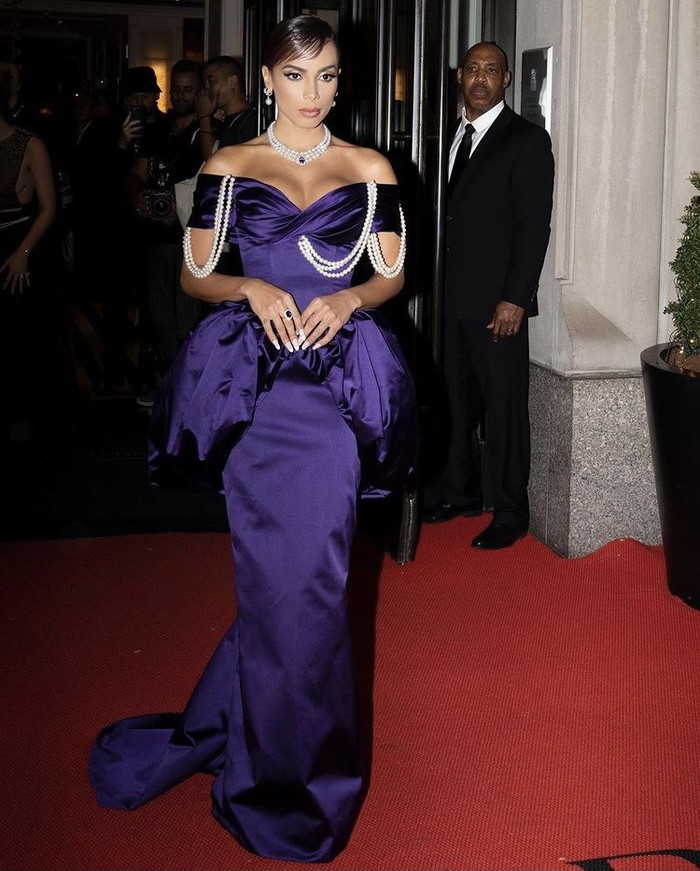 Gaun off-shoulder violet dari Moschino yang dikenakan Anitta memberikan nuansa glamor nan klasik dengan tambahan aksen mutiara dan siluet puffy pada pinggang. Foto: instagram.com/moschino
