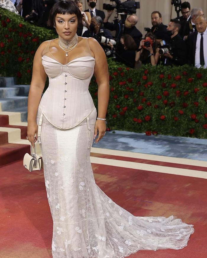Paloma Elsesser memercayakan Coach untuk mendandaninya ke Met Gala 2022. Dengan korset minimalis, outfit terfokus pada ornamen yang menghias train serta aksesori kalung mutiara layer yang memberikan kesan elegan dan mewah. Foto: instagram.com/palomija