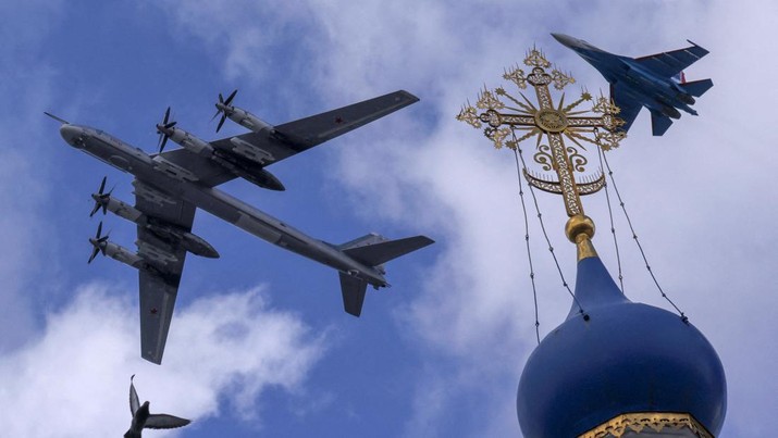 Sebuah pesawat tempur Sukhoi Su-35S Rusia dan pembom strategis Tu-95ms terbang dalam formasi di atas sebuah gereja selama latihan untuk flypast, yang merupakan bagian dari parade militer yang menandai peringatan kemenangan atas Nazi Jerman dalam Perang Dunia Kedua, di Moskow, Rusia, Rabu (4/5/2022). (REUTERS/Maxim Shemetov)