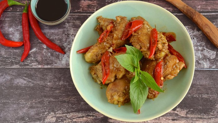 Ayam Kecap. Chicken cooked or stew in thick sweet soy sauce and spices. Garnish with Thai basil