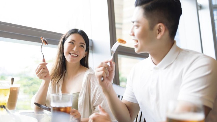 Happy young couple having fun during lunch in restaurant