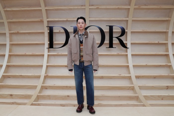Eksplorasi gaya kasual jadi pilihan Jung Hae In. Ia memadukan bomber jacket bersama knit vest serta jeans. Kombinasi tak biasa namun terlihat stylish. Foto: Getty Images for Dior/Myunggu Han