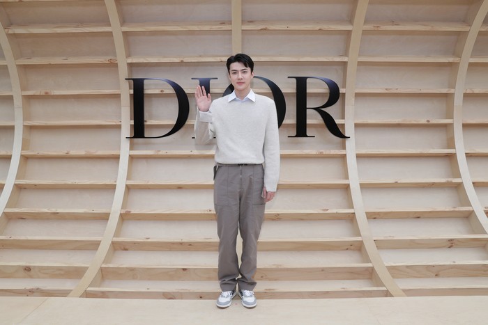 Effortless dan sporty terasa dari gaya berbusana Sehun yang memadukan sweater, kemeja, dan celana cargo aksen zipper. Foto: Getty Images for Dior/Myunggu Han