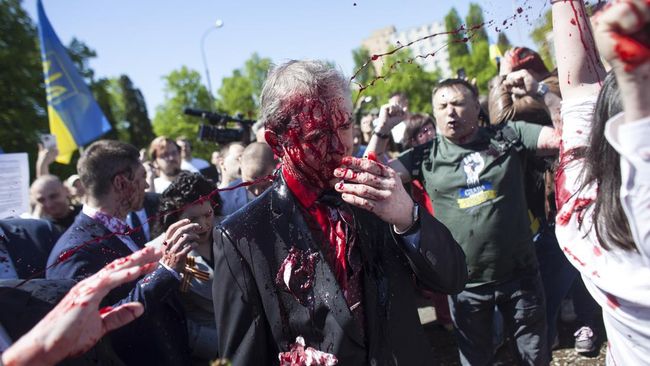 Aktivis pro-Ukraina menyiramkan cairan berwarna merah ke Duta Besar Rusia untuk Polandia, Sergei Andreev, membuat pria itu seperti bersimbah darah.
