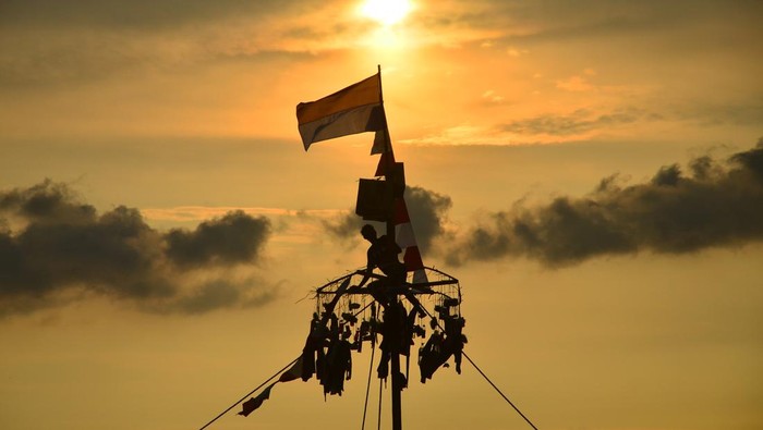 Warga mengibarkan bendera merah putih saat mengikuti lomba Panjat Pinang di kawasan Pantai Kelurahan Demaan, Jepara, Jawa Tengah, Senin (9/5/2022). Panjat Pinang tersebut untuk memeriahkan tradisi Syawalan atau Lebaran ketupat serta untuk menjalin kebersamaan dan menghibur warga. ANTARA FOTO/Yusuf Nugroho/pras.