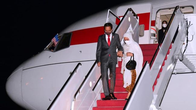 Jokowi dan Iriana Sembari menuruni tangga pesawat  dan berjalan di karpet merah, Jokowi terlihat menggandeng Iriana dengan erat.