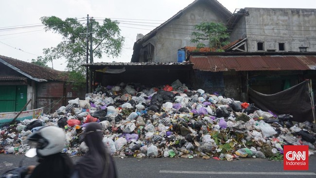 Warung Purwanti yang berada di depan TPS sepi pembeli sejak sampah menggunung tak terangkut. Sementara itu, anak istri Sigit mengungsi ke tempat lain.
