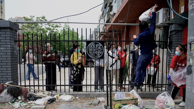 China memindahkan 13 ribu warga perumahan di Beijing ke hotel karantina usai temukan klaster baru dengan 26 kasus Covid-19 di area tersebut.