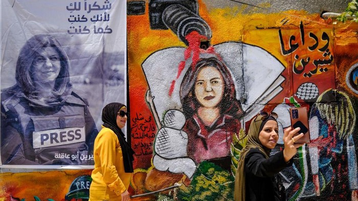 Palestinian schoolgirls approach a drawing on May 19, 2022 at an art exhibit honouring slain Al-Jazeera journalist Shireen Abu Akleh (portraits) at the spot where she was killed on May 11 while covering an Israeli army raid in Jenin in the occupied West Bank. (Photo by RONALDO SCHEMIDT / AFP) (Photo by RONALDO SCHEMIDT/AFP via Getty Images)