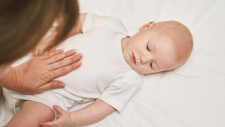 Cute small boy lying at bed. Childhood concept. Light background. Serious child. Copyspace. Stay home. Mockup. Massage. White clothes