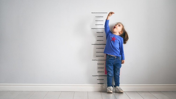 ilustrasi anak Little child is playing superhero. Kid is measuring the growth on the background of wall. Girl power concept.