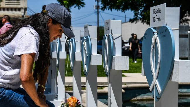 Meghan Markle mengunjungi memorial korban penembakan SD Texas. Ia memberikan bunga di depan peringatan darurat tersebut. 