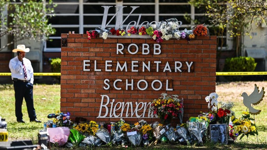 TOPSHOT - Flowers are placed on a makeshift memorial in front of Robb Elementary School in Uvalde, Texas, on May 25, 2022. - The tight-knit Latino community of Uvalde was wracked with grief Wednesday after a teen in body armor marched into the school and killed 19 children and two teachers, in the latest spasm of deadly gun violence in the US. (Photo by CHANDAN KHANNA / AFP) (Photo by CHANDAN KHANNA/AFP via Getty Images)