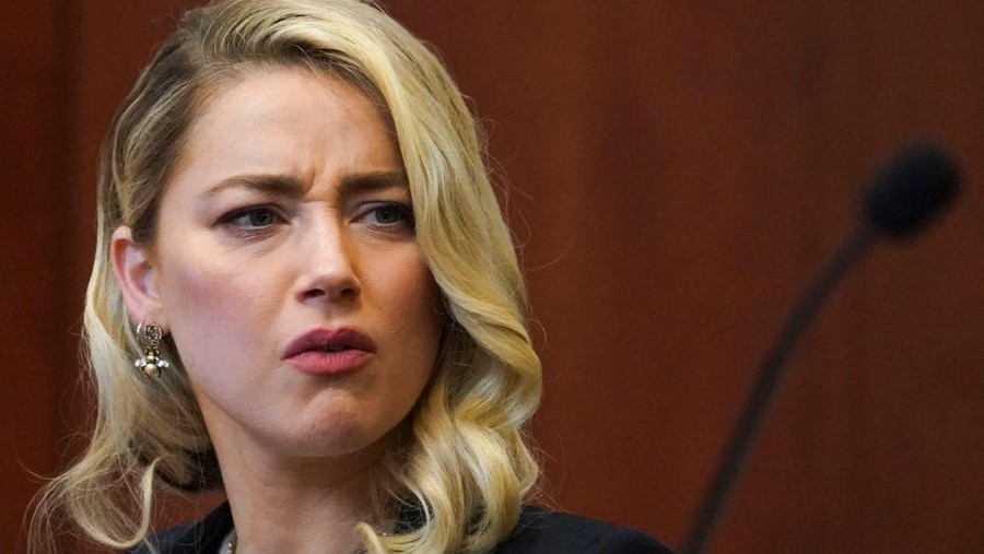 Actor Amber Heard reacts as a pre-recorded deposition testimony of Christian Carino is played during her ex-husband Johnny Depp's defamation trial against her, at the Fairfax County Circuit Courthouse in Fairfax, Virginia, April 27, 2022. - US actor Johnny Depp sued his ex-wife Amber Heard for libel in Fairfax County Circuit Court after she wrote an op-ed piece in The Washington Post in 2018 referring to herself as a "public figure representing domestic abuse." (Photo by JONATHAN ERNST / POOL / AFP) (Photo by JONATHAN ERNST/POOL/AFP via Getty Images)