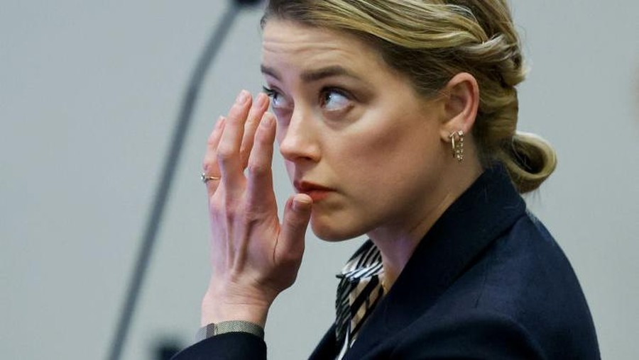 Actor Amber Heard reacts as a pre-recorded deposition testimony of Christian Carino is played during her ex-husband Johnny Depp's defamation trial against her, at the Fairfax County Circuit Courthouse in Fairfax, Virginia, April 27, 2022. - US actor Johnny Depp sued his ex-wife Amber Heard for libel in Fairfax County Circuit Court after she wrote an op-ed piece in The Washington Post in 2018 referring to herself as a "public figure representing domestic abuse." (Photo by JONATHAN ERNST / POOL / AFP) (Photo by JONATHAN ERNST/POOL/AFP via Getty Images)