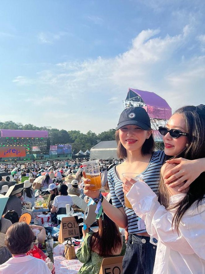 Wendy dan Irene Red Velvet menunjukkan kebersamaan mereka dengan menghabiskan waktu menonton festival. Di bawah terik sinar matahari, keduanya tampak menikmati festival sembari berpose dengan minuman di tangan mereka./Foto: instagram.com/todayis_wendy
