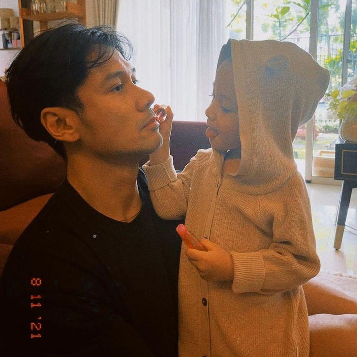 <p>Lahir pada 24 September 2018 lalu, Surinala yang potretnya jarang diperlihatkan itu kini sudah besar, Bunda. Sang ayah, Chicco Jerikho beberapa kali mengunggah momen kebersamaannya dengan Suri. Seperti di foto ini, saat Suri memakaikan lipstik pada bibir Chicco. (Foto: Instagram @chicco.jerikho)</p>