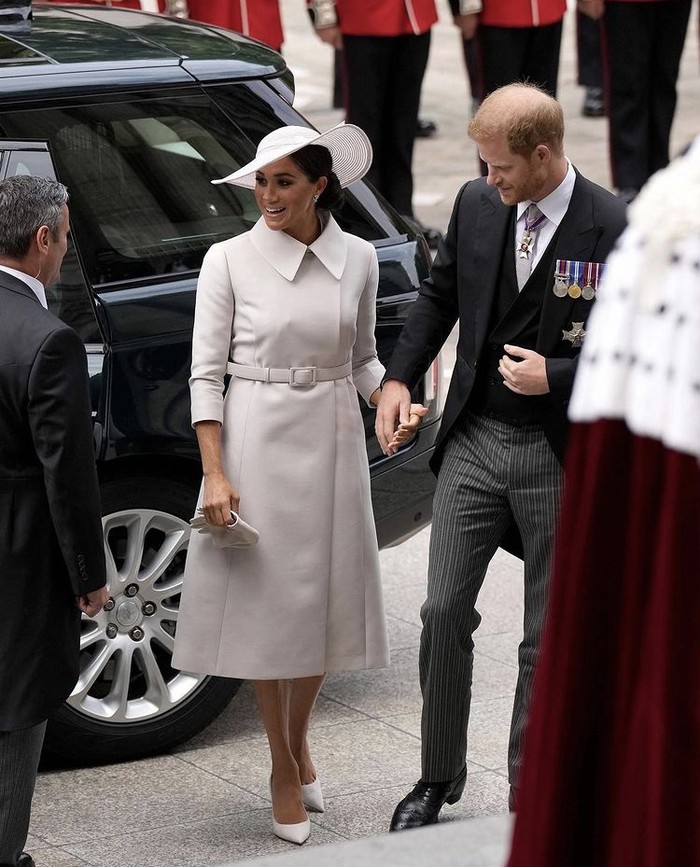 Meghan Markle dan Pangeran Harry turut memeriahkan Platinum Jubilee. Keduanya tampil paripurna di mana Pangeran Harry kenakan tailcoat suit, sedangkan Meghan coat dress aksen belt dan topi berwarna senada. Foto: instagram.com/bazaaruk