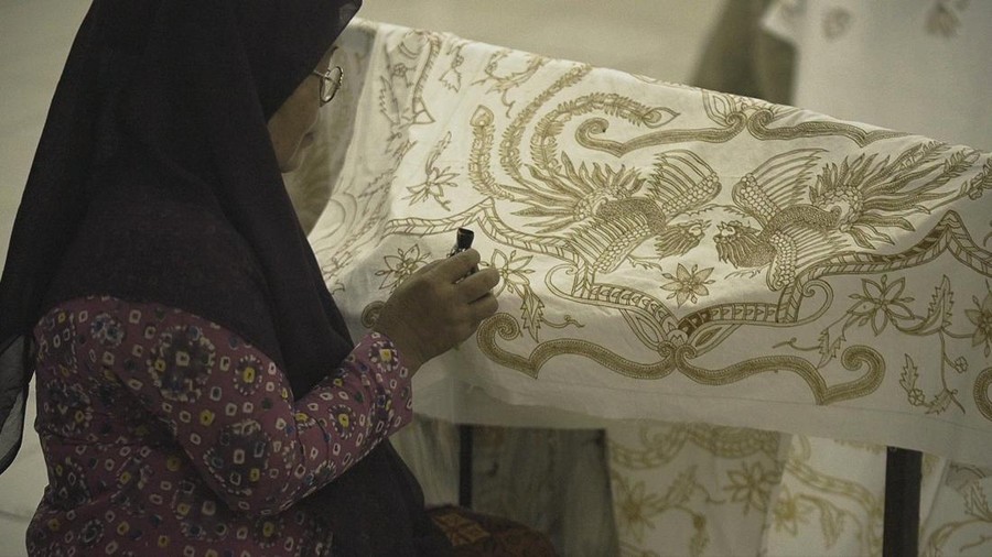 Seorang perajin sedang membuat batik Danar Hadi dengan canting