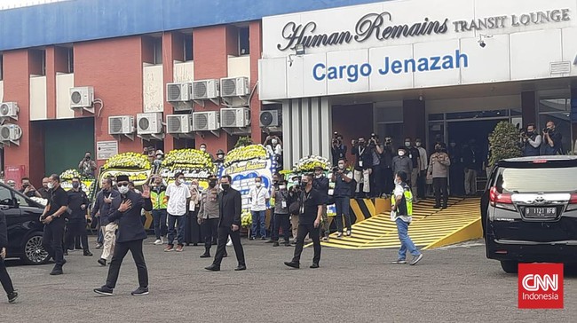 Ridwan Kamil tampak memakai jas, celana, peci, dan sepatu hitam. Ia juga menutupi wajahnya dengan kacamata hitam.