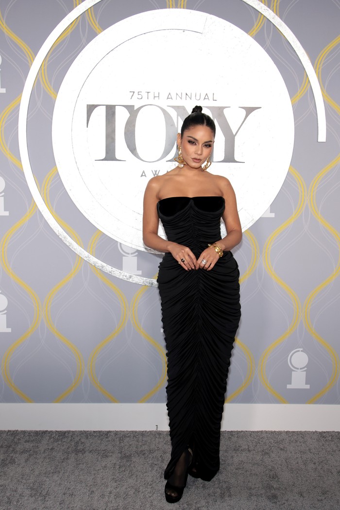 Gaun hitam juga jadi pilihan Vanessa Hudgens. Bedanya ia memilih potongan yang lebih fitted sehingga berkesan lebih sexy. Ia juga menambahkan perhiasan emas yang chunky sebagai pelengkap. Gaun tersebut merupakan rancangan rumah mode Schiaparelli. Foto: Getty Images for Tony Awards Pro/Dimitrios Kambouris