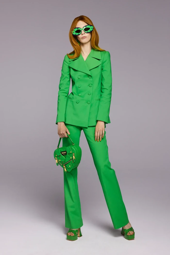 Penyuka setelan celana, bersiap untuk memakai varian warna yang lebih vibran seperti hijau. Pasangkan bersama aksesori bergaya quirky seperti sunglasses. Foto: Marcus Mam / Courtesy of Moschino