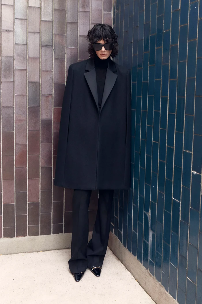 Coat tanpa lengan atau yang populer dengan sebutan cape kembali populer. Pilih dengan model berkerah seperti jas dan kenakan bersama skinny pants berwarna senada untuk gaya formal yang lebih fresh dan boyish. Foto: Courtesy of Saint Laurent