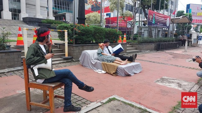 Aksi teatrikal digelar komunitas teater Pasar Senen mengkritik Ketua MK Anwar Usman yang tak mundur dari jabatan hakim konstitusi usai menikahi adik Jokowi.