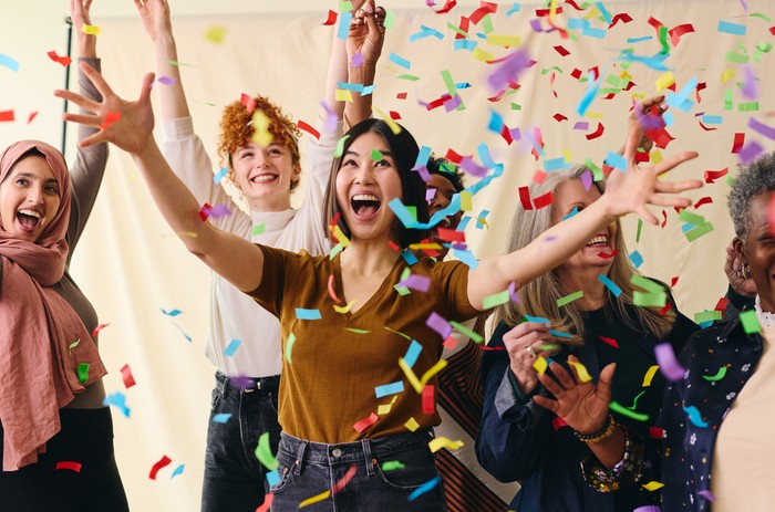 Action shot of mixed age range multi ethnic women celebrating International Women's Day with ticker tape