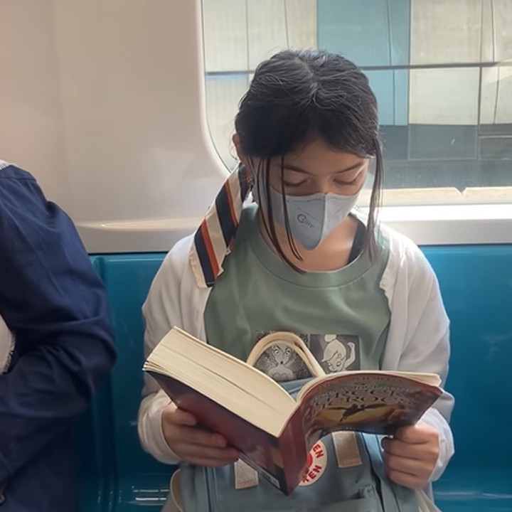 <p>Ketika berada di dalam MRT, Sienna tampak asyik dengan buku bacaannya. (Foto: Instagram @nesyanabila)</p>
