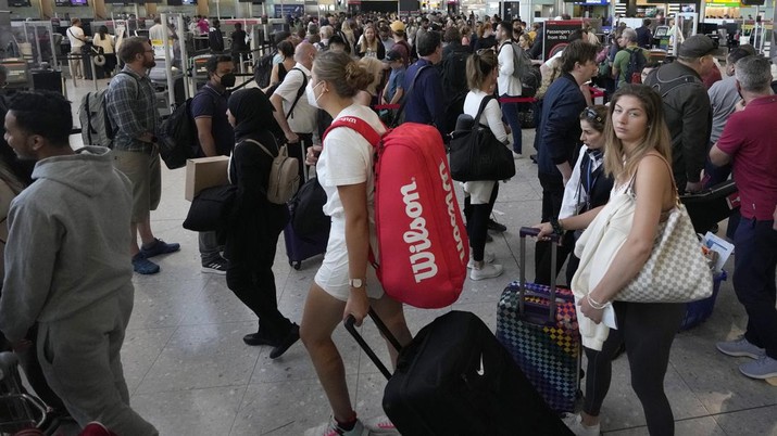 Travellers queue at security at Heathrow Airport in London, Wednesday, June 22, 2022. After two years of pandemic restrictions, travel demand is back with a vengeance but airlines and airports that slashed jobs during the depths of the COVID-19 crisis are struggling to keep up. With the busy summer tourism season underway in Europe, passengers are encountering chaotic scenes at airports, including lengthy delays, canceled flights and headaches over lost luggage. (AP Photo/Frank Augstein)